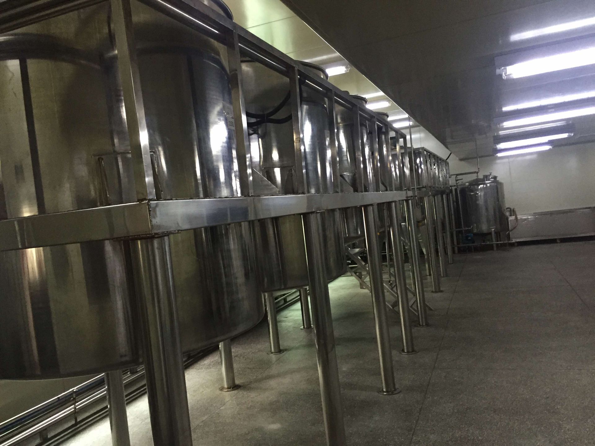 Row of stainless-steel production tanks in the processing workshop